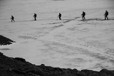 People on beach against sky during winter