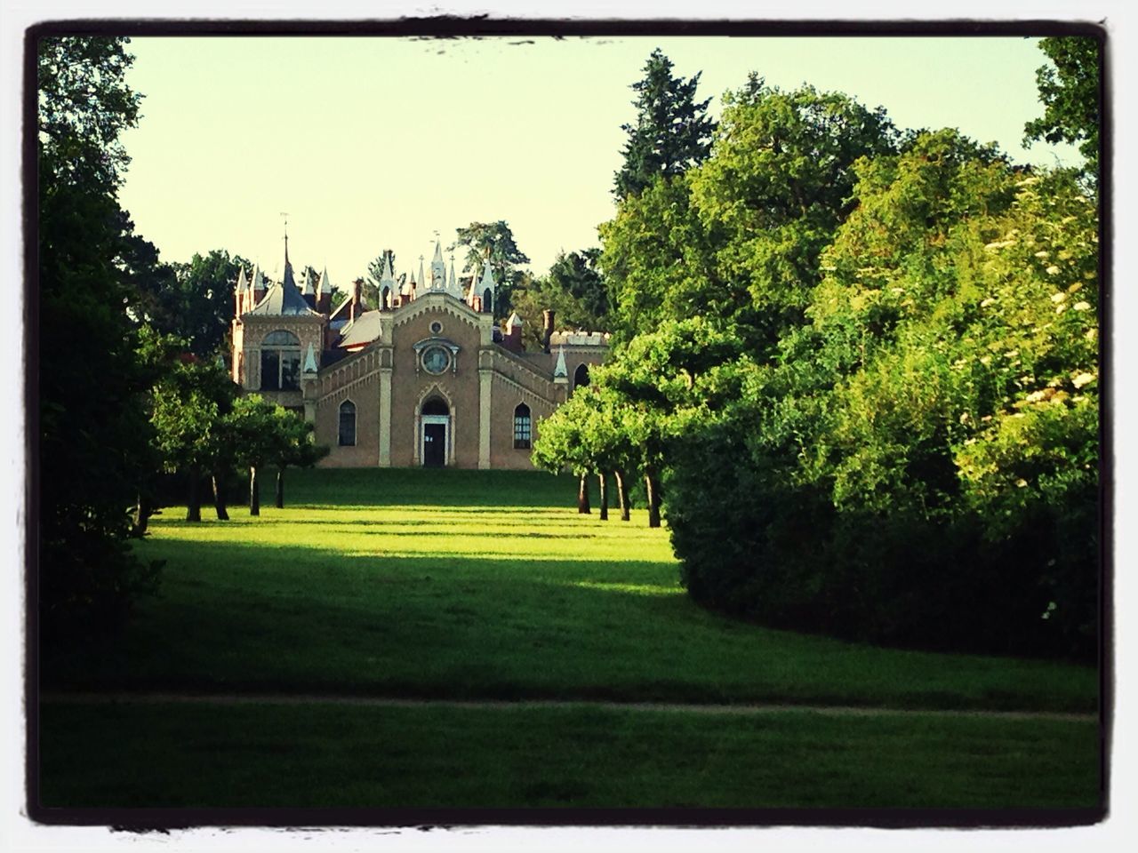 architecture, building exterior, built structure, tree, grass, lawn, clear sky, green color, transfer print, history, sky, religion, famous place, facade, travel destinations, place of worship, day, formal garden, auto post production filter