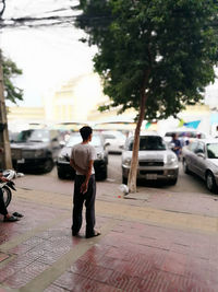 Rear view of man standing on street in city