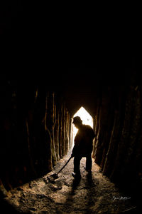 Rear view of silhouette man standing in tunnel