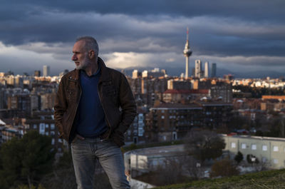 Adult man looking at city skyline of madrid, spain, during sunset