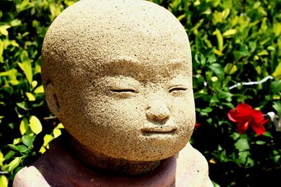 Close-up of buddha statue against plants