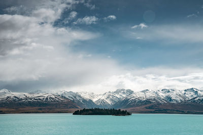 A scenic landscape of new zealand southern alps and lake tekapo with blue sky and clouds.