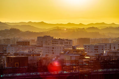 High angle view of buildings in city during sunset