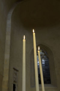 Low angle view of illuminated candles against building