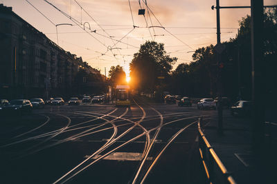 Road in city against sky during sunset