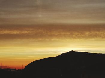 Scenic view of silhouette mountains against orange sky