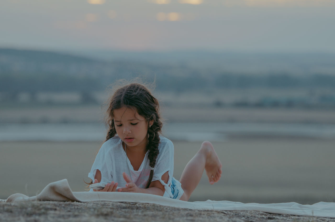 one person, real people, childhood, child, leisure activity, sea, lifestyles, land, water, focus on foreground, beach, front view, headshot, nature, sky, day, girls, innocence, outdoors