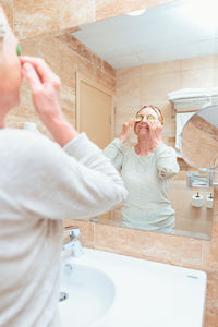 Portrait of smiling young woman drinking water at home