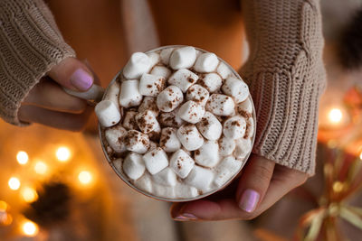 Woman hands holding a cup of coffee. cozy winter concept.hot chocolate or cocoa with marshmallow 