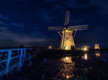 Traditional windmill against sky at night