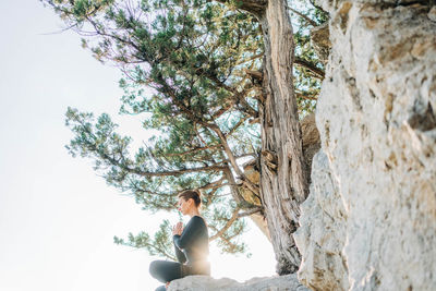 Portrait of woman sitting on rock