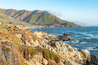 Scenic view of sea and mountains against sky