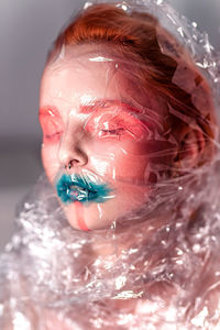 Close-up portrait of young woman wearing polythene mask