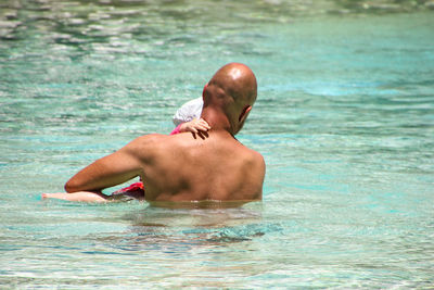 Low section of man swimming in pool