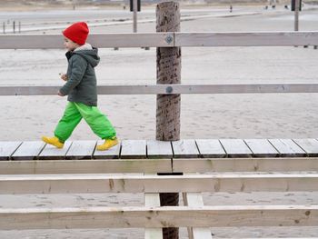 Full length of boy climbing on snow