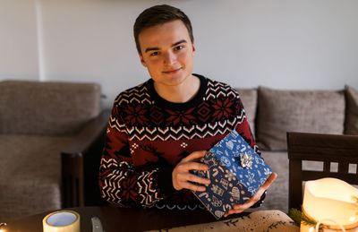 Young man holding a carefully wrapped christmas present