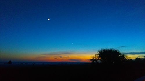 Scenic view of silhouette landscape against blue sky at night