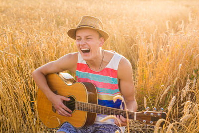 Smiling young man playing guitar