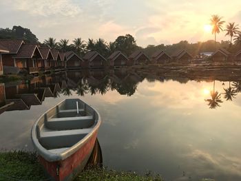 Scenic view of swimming pool by lake against sky during sunset