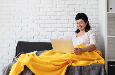 Young woman using mobile phone while sitting in office