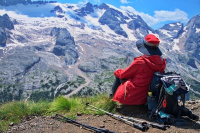 Senior woman sitting on mountain peak with beautiful view in background