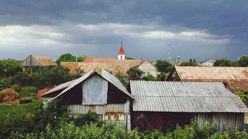 Houses in city against cloudy sky