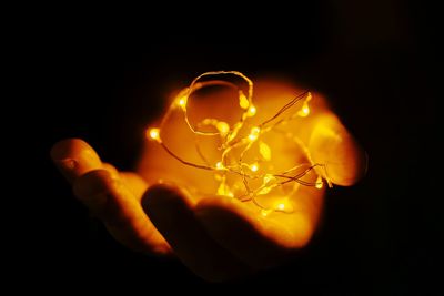Close-up of illuminated light bulb against black background