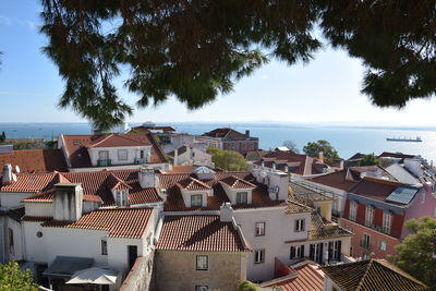 High angle view of townscape by sea against sky