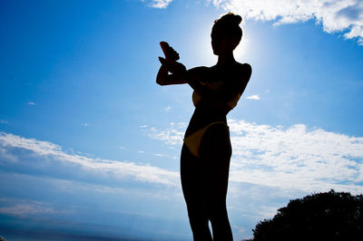 Silhouette woman standing against blue sky