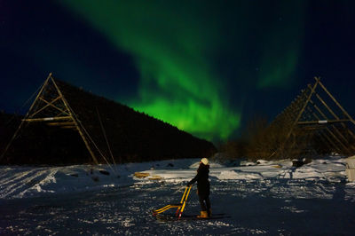 Woman standing on snow covered mountain at night