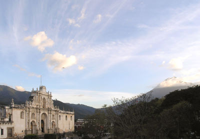 Buildings in city against cloudy sky