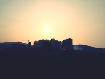 Silhouette built structures at sunset