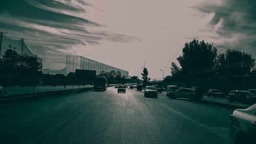 Cars on road against sky in city