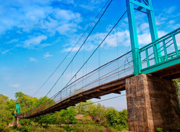 Low angle view of bridge against cloudy sky