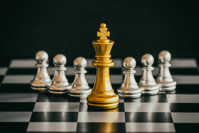 Close-up of chess pieces on board against black background