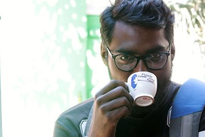 Close-up of young man holding eyeglasses