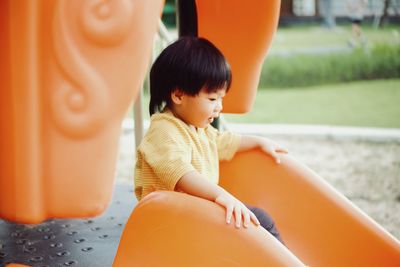 Portrait of boy sitting on slide