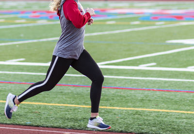 Full length of woman running on grassland