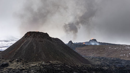 Smoke emitting from volcanic mountain against sky