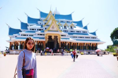 Portrait of woman standing against shrine