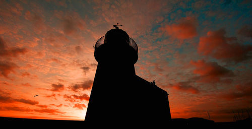 Low angle view of silhouette tower against sky during sunset