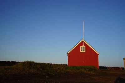 Built structure on landscape against clear blue sky