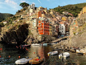 Boats moored on sea by buildings in city