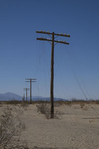 Wind turbines on desert against clear blue sky