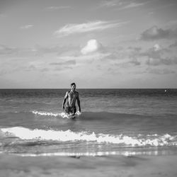 Men in sea against sky