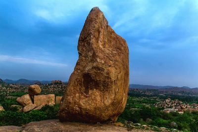 View of rock formation against cloudy sky