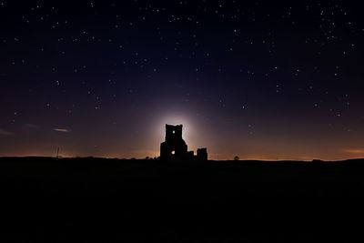 Silhouette of built structure against sky at night