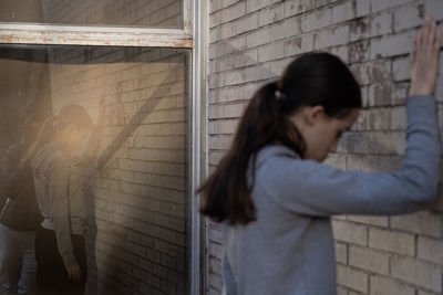 Side view of woman looking through window