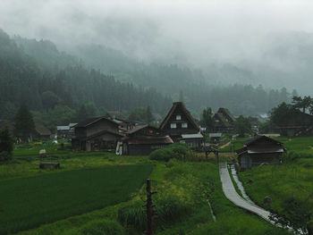 Scenic view of landscape and buildings during foggy weather